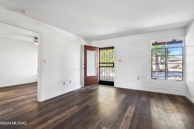 spare room with dark hardwood / wood-style floors and a healthy amount of sunlight