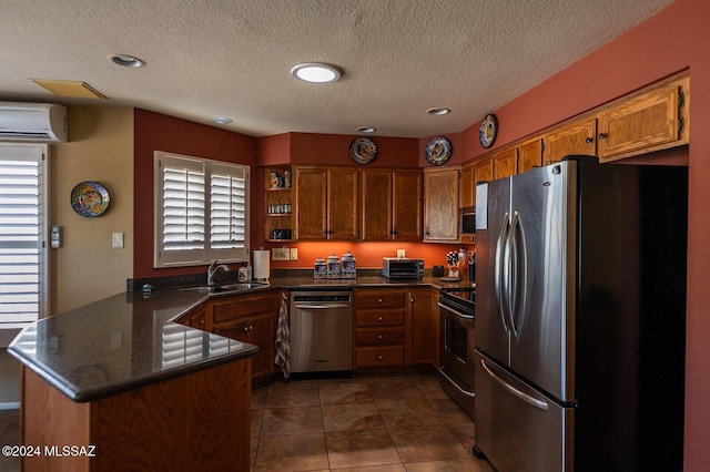 kitchen featuring kitchen peninsula, a textured ceiling, stainless steel appliances, and a healthy amount of sunlight