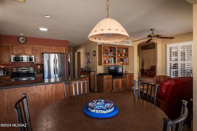 dining area with ceiling fan and a textured ceiling