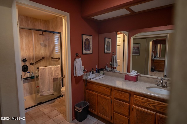 bathroom with tile patterned flooring, vanity, toilet, and a shower with shower door