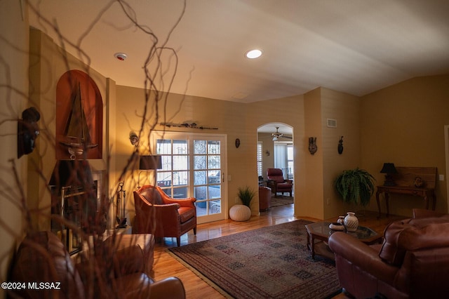 living room featuring light hardwood / wood-style floors, ceiling fan, and lofted ceiling