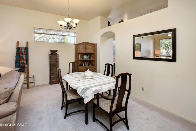 carpeted dining area with a notable chandelier