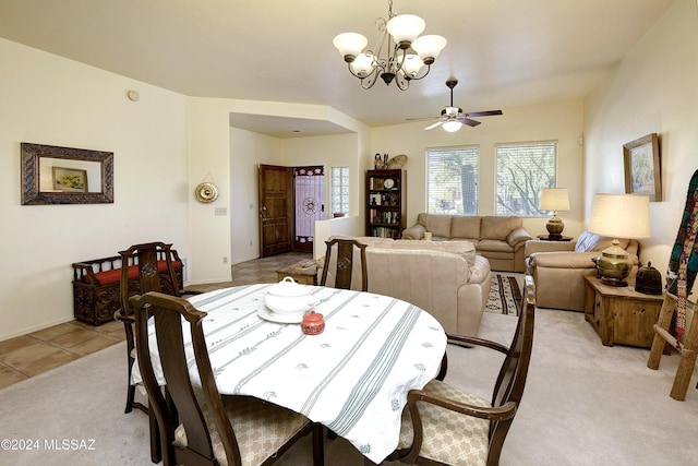 carpeted dining area featuring ceiling fan with notable chandelier