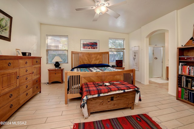 bedroom with connected bathroom, ceiling fan, and light hardwood / wood-style flooring