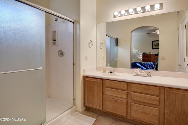 bathroom featuring tile patterned flooring, ceiling fan, walk in shower, and vanity