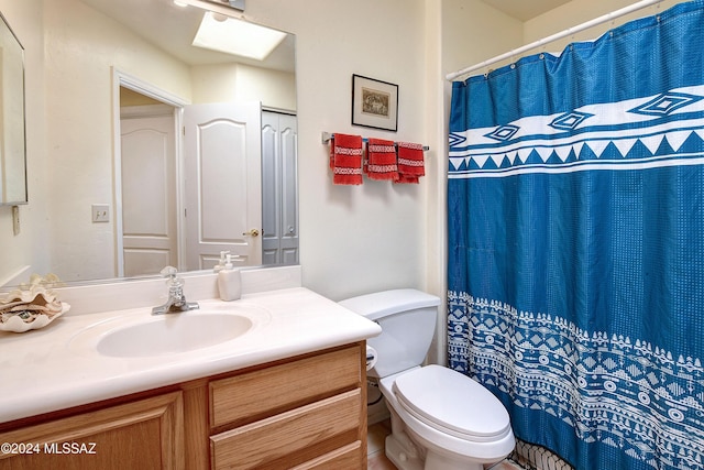 bathroom featuring vanity, a skylight, and toilet