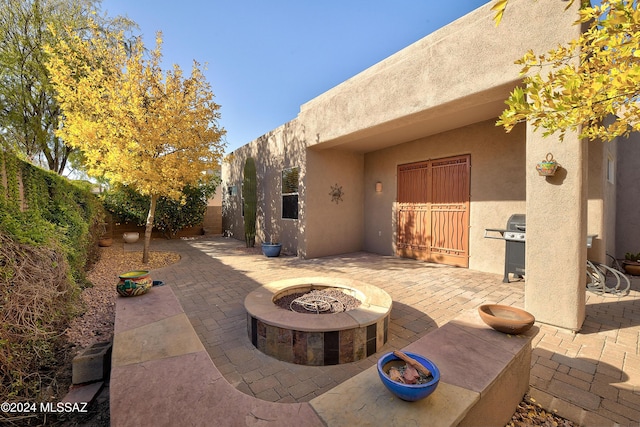 view of patio featuring an outdoor fire pit and a grill