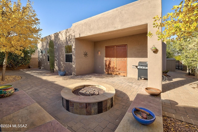 back of property featuring a patio and a fire pit