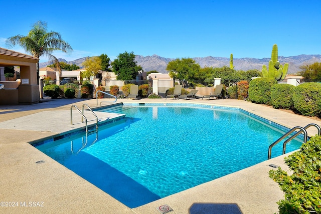 view of swimming pool with a mountain view and a patio