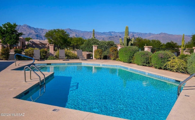 view of swimming pool with a mountain view