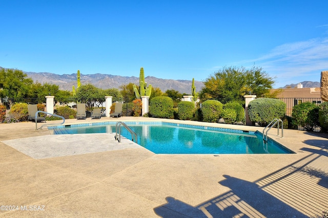 view of swimming pool featuring a mountain view and a patio