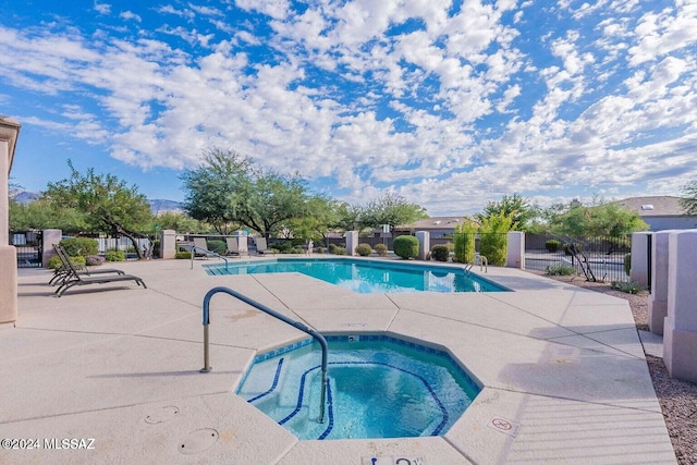 view of pool with a patio and a hot tub