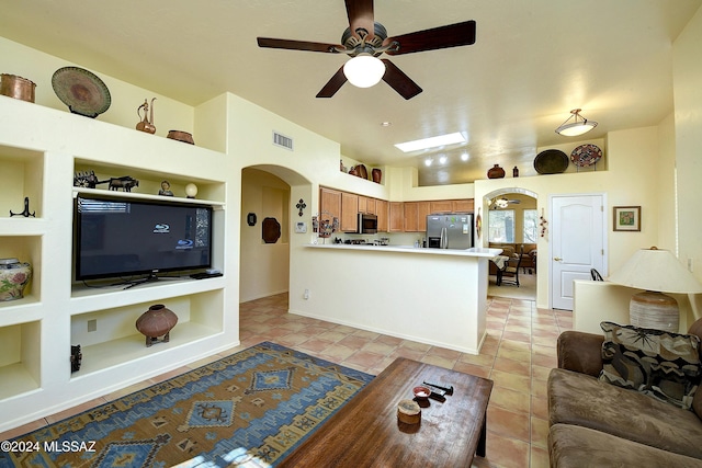 tiled living room with built in shelves and ceiling fan