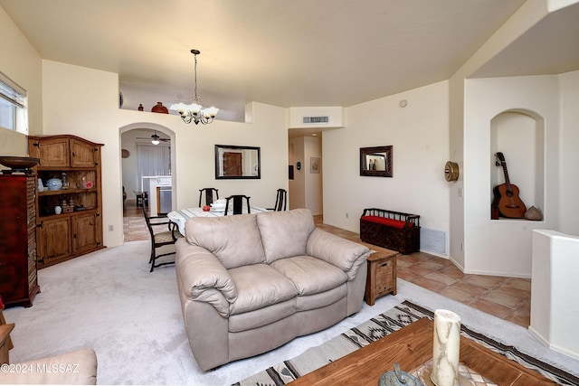 tiled living room featuring ceiling fan with notable chandelier