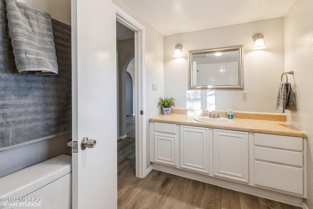 bathroom with hardwood / wood-style flooring, vanity, and toilet