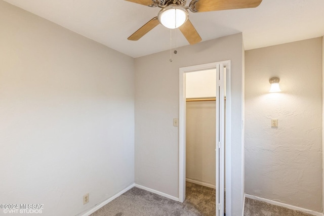 unfurnished bedroom featuring ceiling fan, carpet, a closet, and a walk in closet