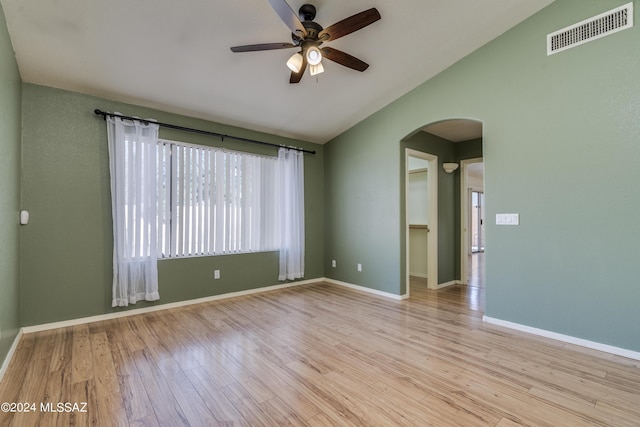 spare room featuring ceiling fan, light wood-type flooring, and vaulted ceiling