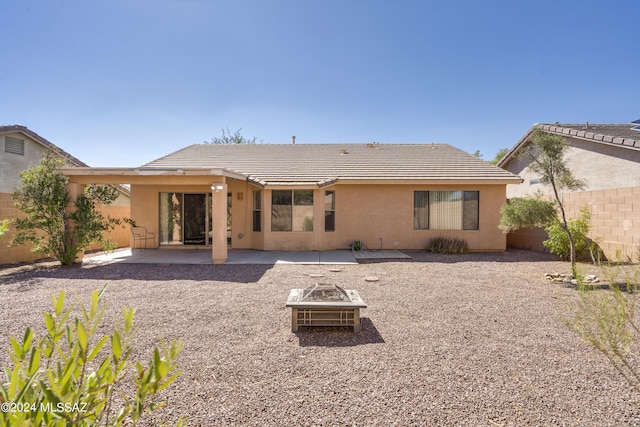 back of house with a fire pit and a patio area