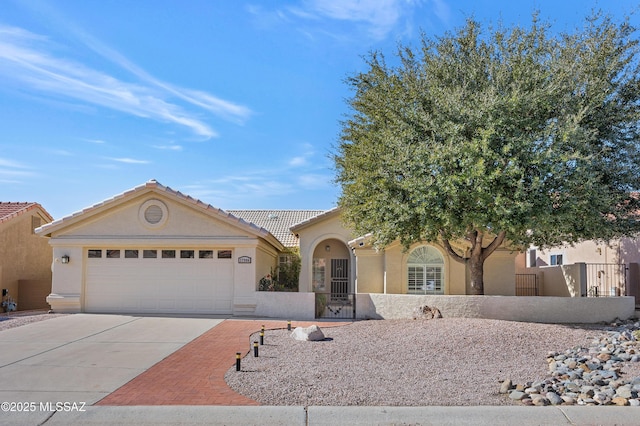 single story home featuring a garage, driveway, fence, and stucco siding