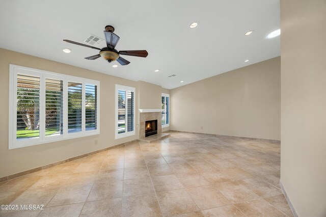 unfurnished living room with arched walkways, visible vents, recessed lighting, lofted ceiling, and a tile fireplace