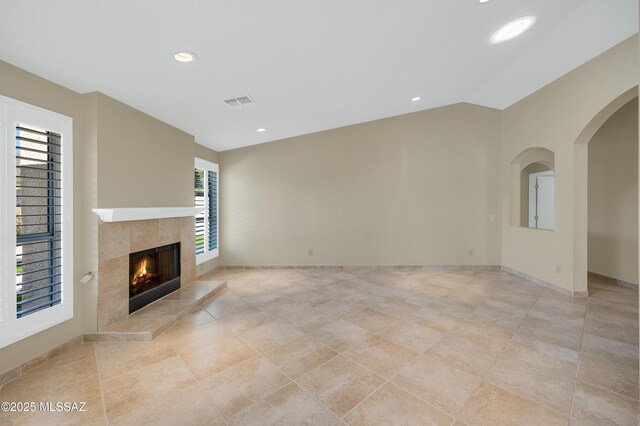 kitchen featuring arched walkways, a sink, stainless steel microwave, gas stove, and open shelves