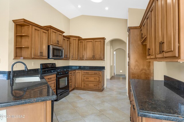 kitchen featuring a peninsula, a sink, vaulted ceiling, brown cabinets, and black appliances