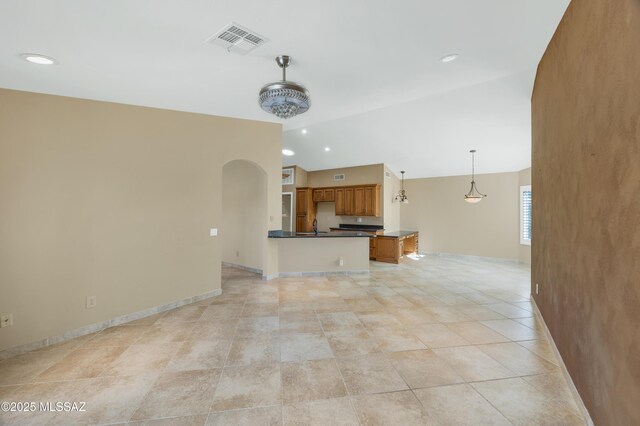 living area featuring vaulted ceiling, arched walkways, baseboards, visible vents, and recessed lighting