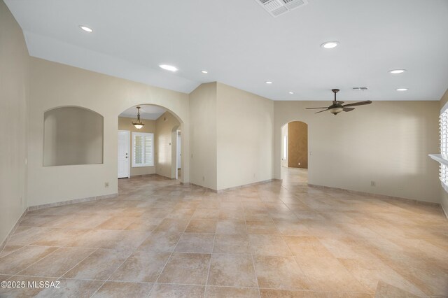 foyer featuring arched walkways, visible vents, and baseboards