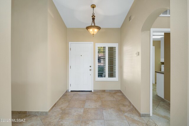unfurnished room with ceiling fan, vaulted ceiling, and light tile patterned floors