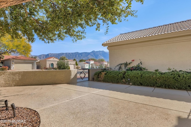 view of patio / terrace with a gate, a mountain view, and a residential view