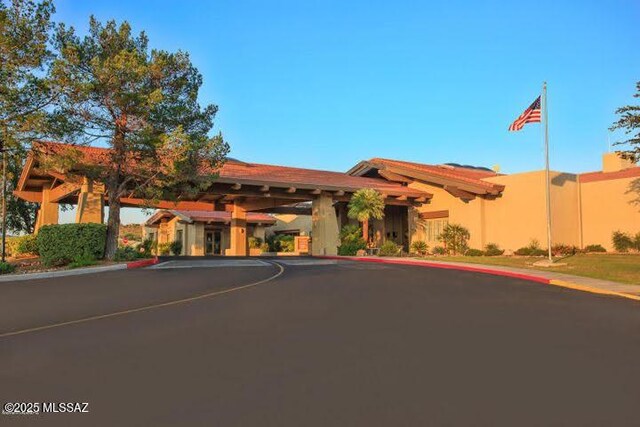 view of front facade with fence, uncovered parking, and stucco siding