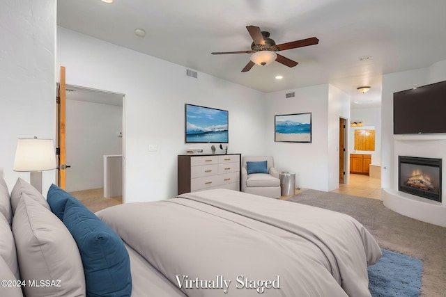 bedroom with light carpet, ceiling fan, and ensuite bathroom