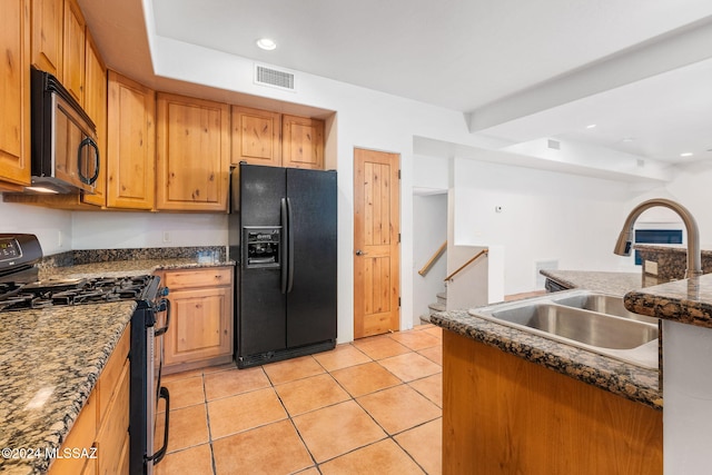 kitchen with black appliances, light tile patterned floors, sink, and dark stone counters