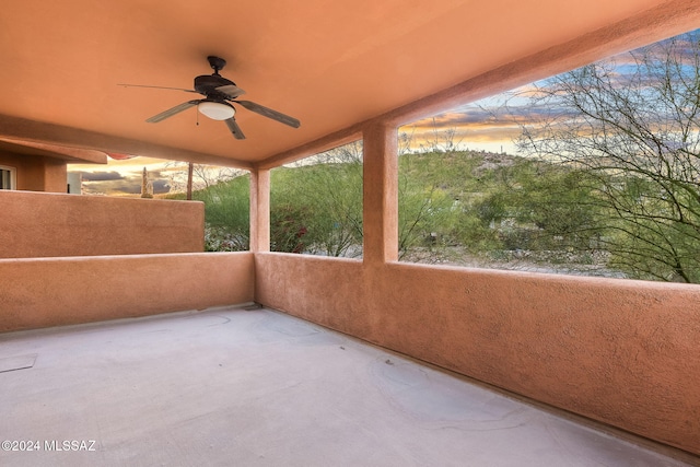 patio terrace at dusk featuring ceiling fan