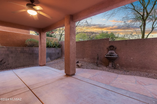 patio terrace at dusk featuring ceiling fan