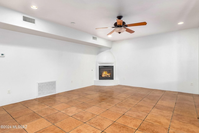 unfurnished living room featuring light tile patterned floors and ceiling fan