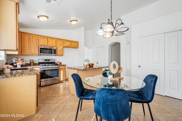 kitchen with stainless steel appliances, vaulted ceiling, sink, decorative light fixtures, and an inviting chandelier