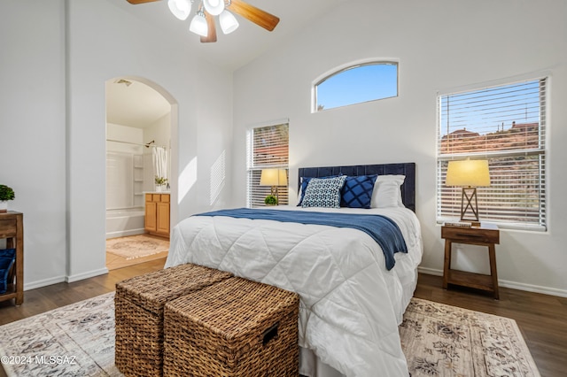 bedroom with hardwood / wood-style flooring, ceiling fan, vaulted ceiling, and ensuite bath