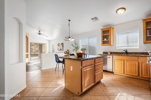 kitchen featuring ceiling fan with notable chandelier, a center island, stainless steel dishwasher, and light tile patterned flooring