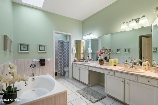 full bathroom featuring vanity, a skylight, tile patterned flooring, toilet, and independent shower and bath