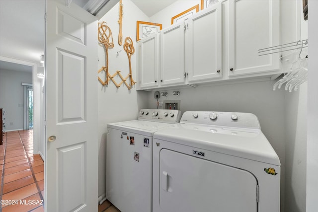 washroom featuring light tile patterned flooring, cabinets, and washing machine and dryer