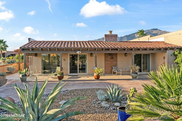 rear view of property featuring a patio area and a mountain view