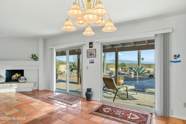 doorway to outside featuring tile patterned floors, a chandelier, and a tiled fireplace