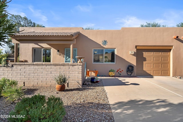 southwest-style home with concrete driveway, an attached garage, and stucco siding