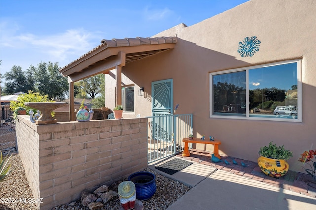 doorway to property featuring a patio area and stucco siding