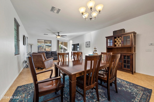 tiled dining area with ceiling fan with notable chandelier