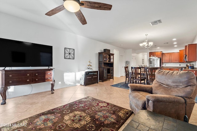 tiled living room featuring ceiling fan with notable chandelier