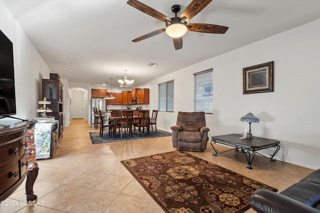 tiled living room featuring ceiling fan with notable chandelier