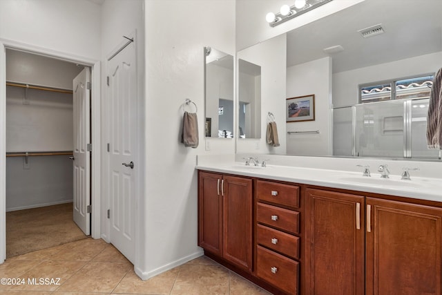 bathroom with vanity, tile patterned floors, and a shower with door