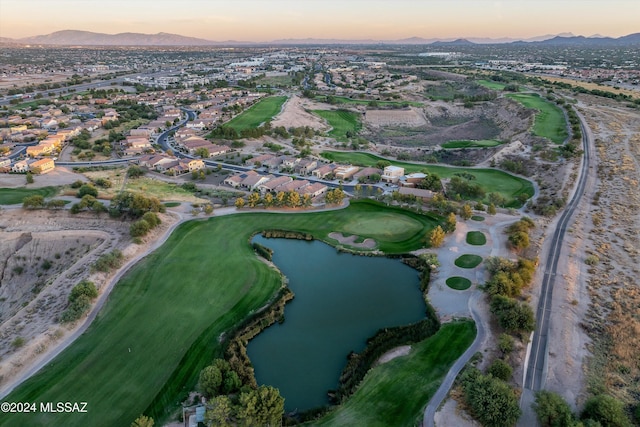 aerial view at dusk featuring a water and mountain view